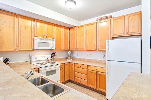 kitchen featuring light tile patterned floors, white appliances, and sink