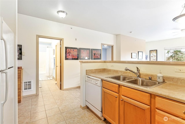 kitchen with light tile patterned flooring, white appliances, and sink