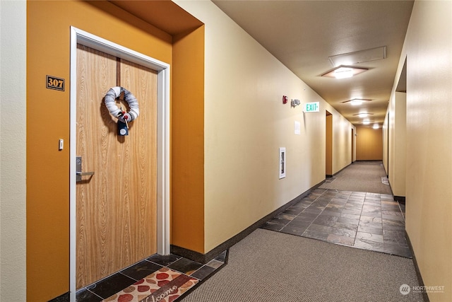 hall with dark colored carpet