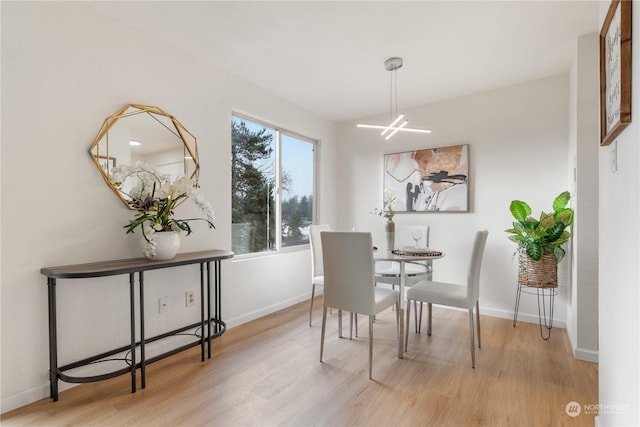 dining room with light hardwood / wood-style floors and a chandelier