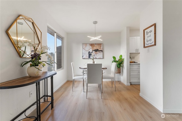 dining area featuring light hardwood / wood-style floors and a notable chandelier