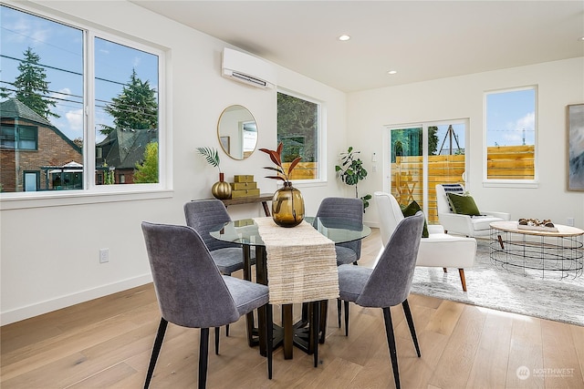 dining room with light hardwood / wood-style floors and a wall unit AC