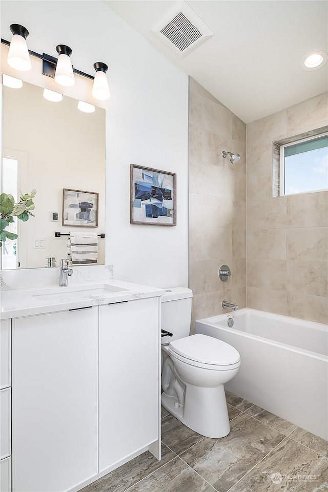 full bathroom with vanity, toilet, and tiled shower / bath