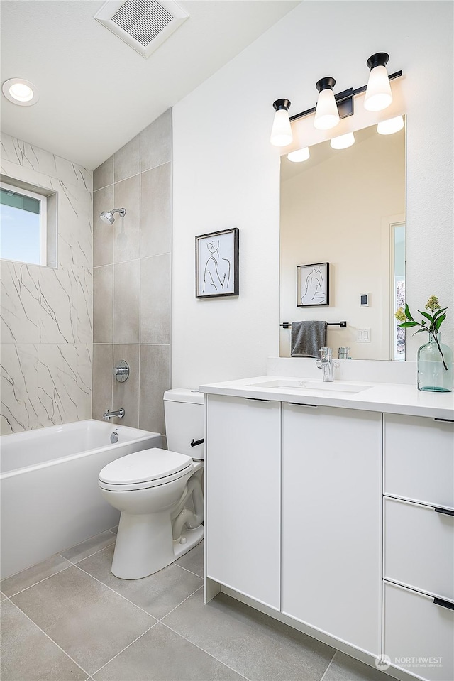 full bathroom featuring tiled shower / bath combo, toilet, and vanity