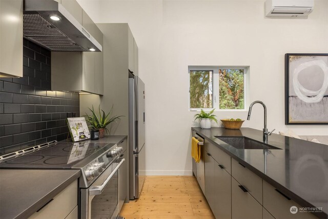 kitchen featuring sink, wall chimney exhaust hood, decorative backsplash, a wall mounted AC, and stainless steel appliances