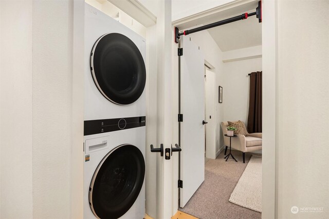 laundry room with carpet and stacked washer and dryer