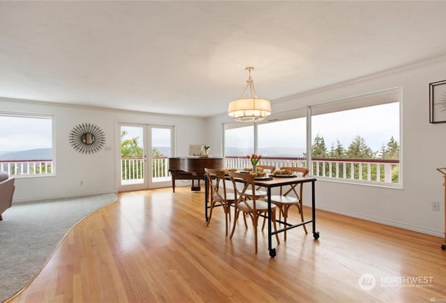 dining space featuring light hardwood / wood-style flooring, french doors, and ornamental molding