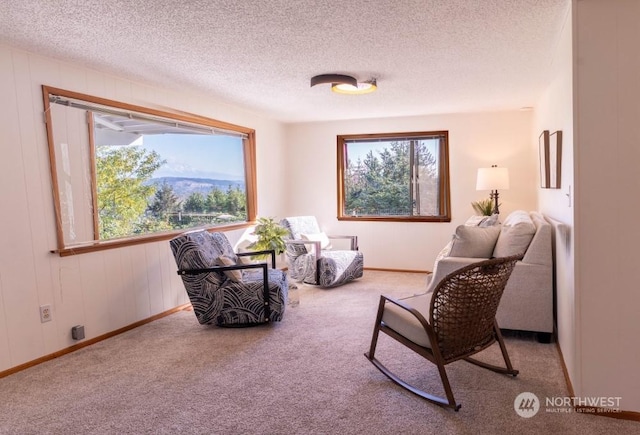 sitting room with light carpet, a textured ceiling, and wooden walls