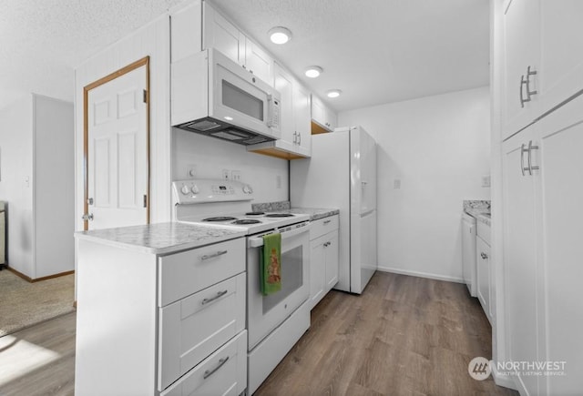 kitchen featuring white cabinets, light hardwood / wood-style floors, white appliances, and a textured ceiling