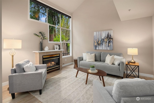 living room featuring light hardwood / wood-style floors, lofted ceiling, and a fireplace