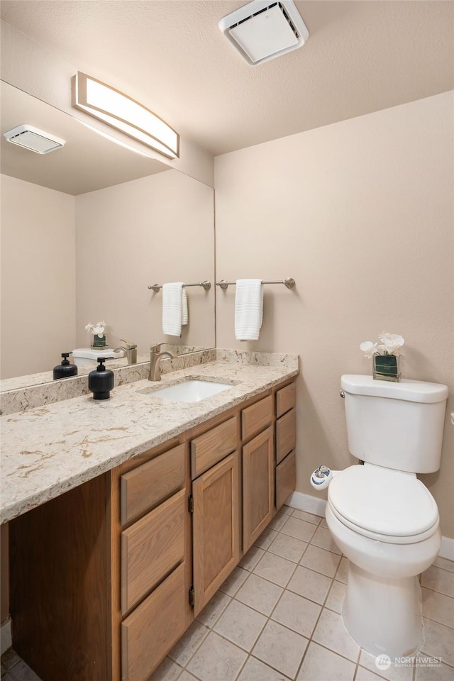 bathroom with tile patterned flooring, vanity, and toilet