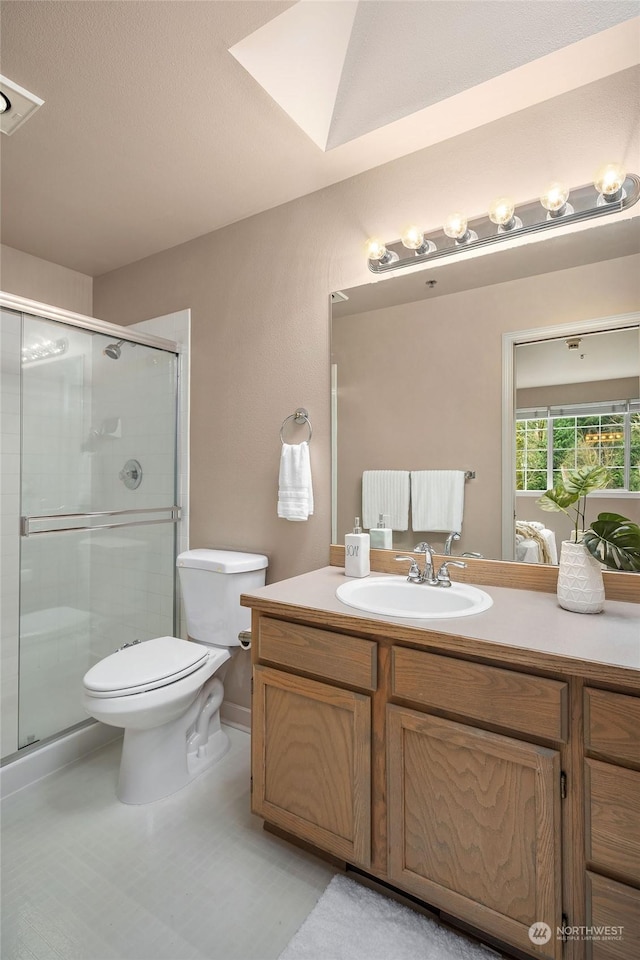 bathroom with vanity, toilet, and a shower with shower door