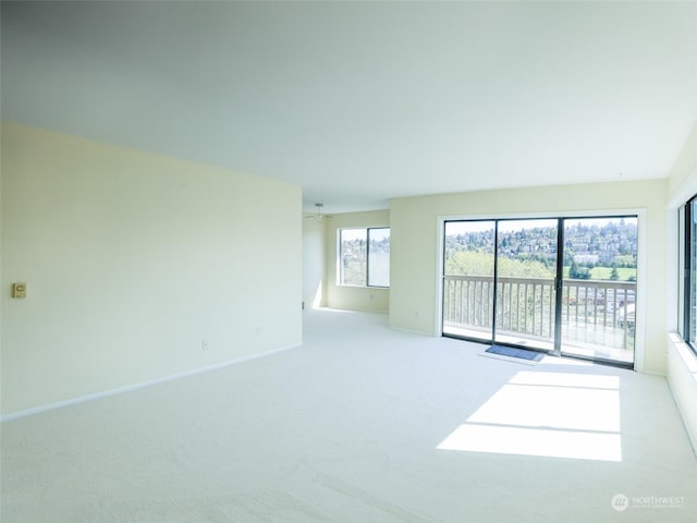 carpeted spare room with ceiling fan