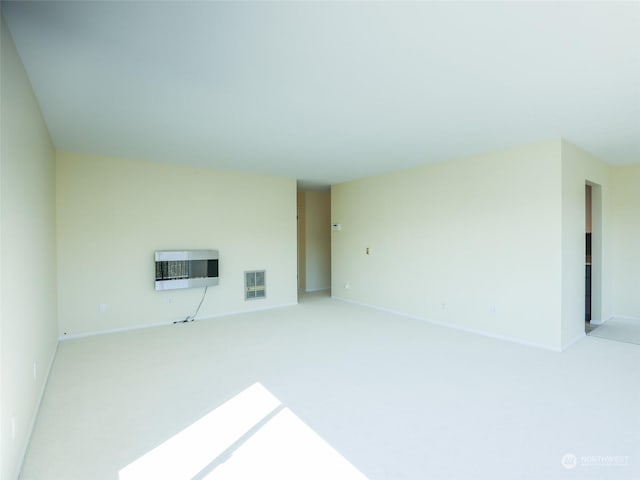 unfurnished living room featuring heating unit and carpet