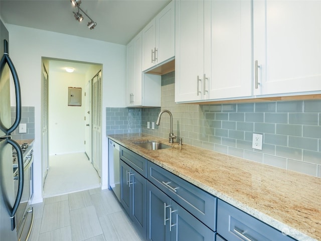 kitchen with decorative backsplash, light stone counters, stainless steel dishwasher, sink, and white cabinets