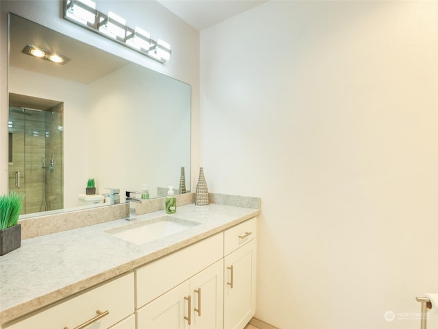 bathroom with vanity, toilet, and a shower with door