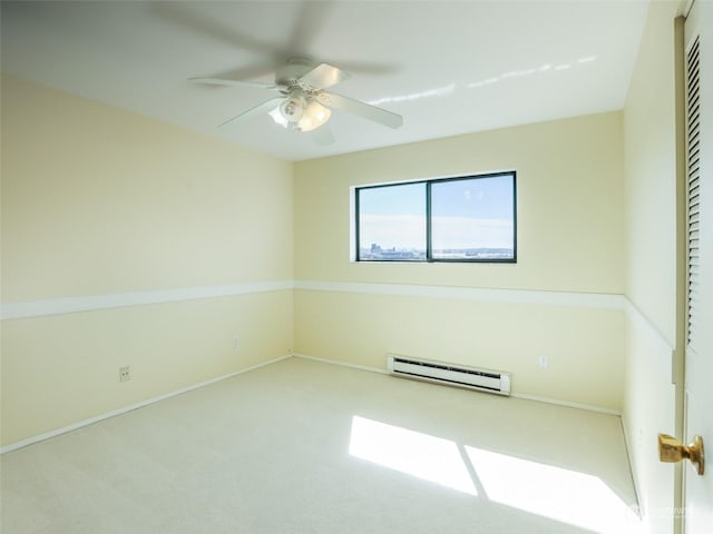 carpeted empty room featuring ceiling fan and a baseboard heating unit