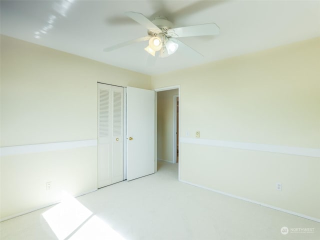 unfurnished bedroom with carpet, ceiling fan, and a closet