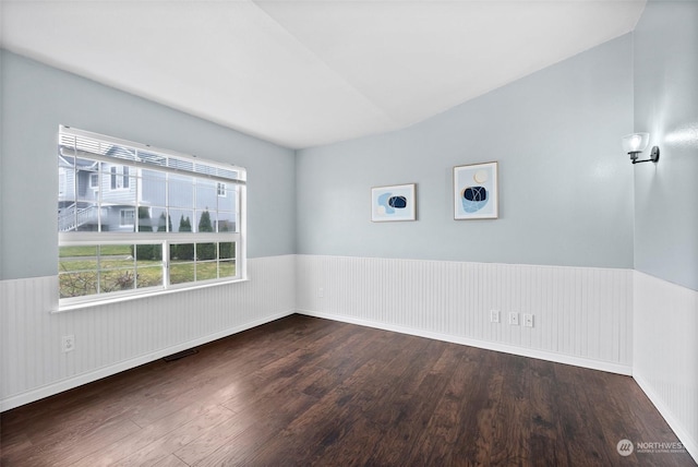 unfurnished room with lofted ceiling and dark wood-type flooring