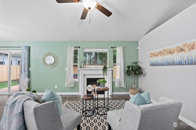 living room with a fireplace, ceiling fan, and wood-type flooring