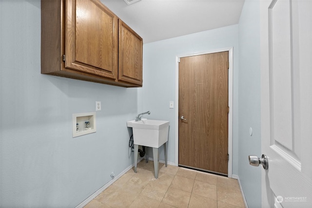 washroom with washer hookup, cabinets, and light tile patterned floors