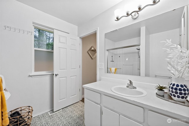 bathroom with tile patterned flooring, a shower with shower door, and vanity