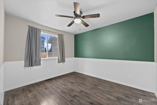 empty room with dark hardwood / wood-style flooring and ceiling fan