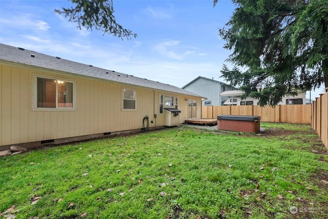 back of property with a yard and a hot tub