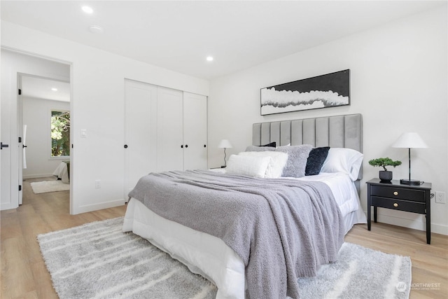 bedroom with light hardwood / wood-style floors and a closet