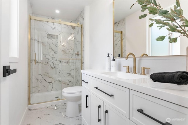 bathroom featuring vanity, a shower with shower door, and toilet