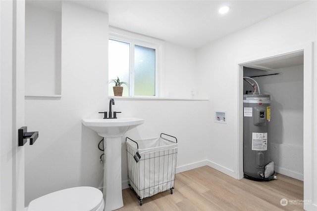 bathroom with toilet, wood-type flooring, and water heater