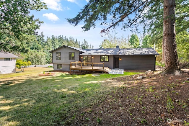 rear view of house with a wooden deck and a yard