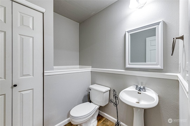 bathroom with toilet, wood-type flooring, and sink