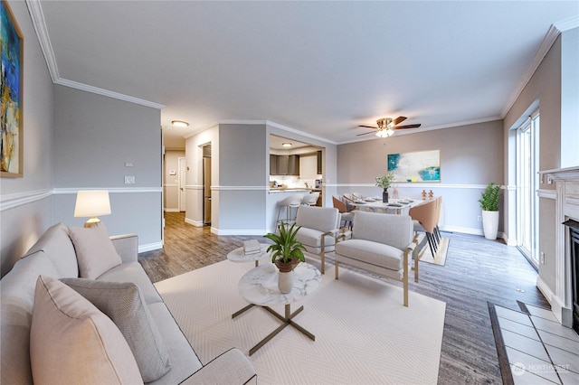 living room with hardwood / wood-style floors, ceiling fan, and crown molding