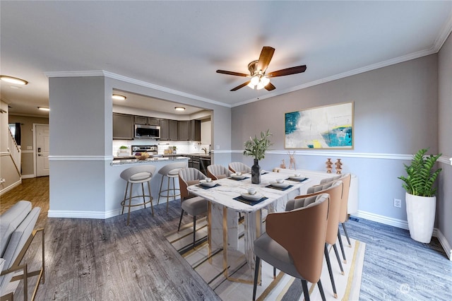 dining area with ceiling fan, dark hardwood / wood-style flooring, and ornamental molding