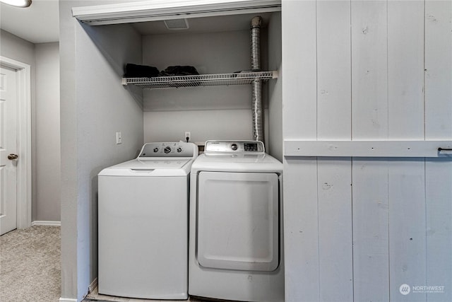 laundry room with washer and clothes dryer and light colored carpet