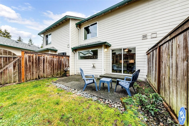 rear view of house featuring a yard and a patio