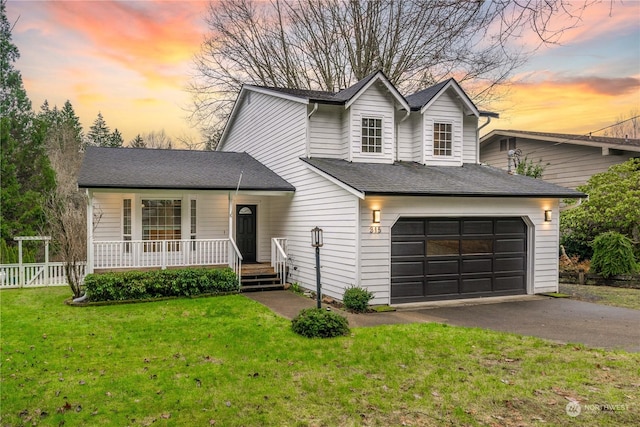 view of front of house with a lawn, a garage, and covered porch