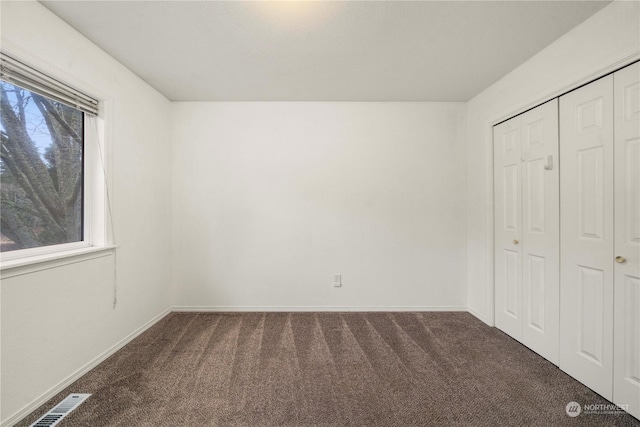 unfurnished bedroom with a closet, carpet floors, and multiple windows