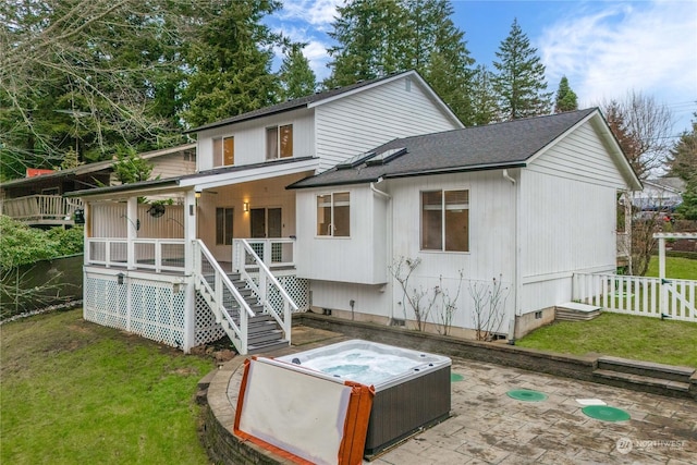 back of house featuring a porch and a hot tub