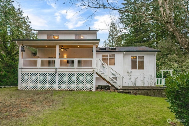 rear view of house with ceiling fan and a yard