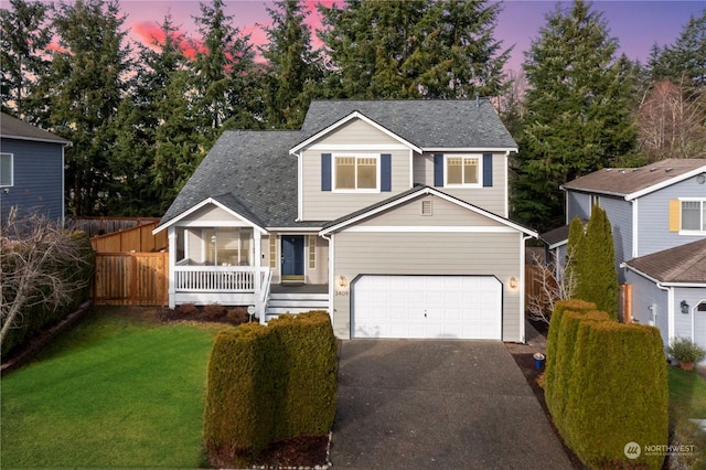 view of front of house featuring a lawn, a porch, and a garage