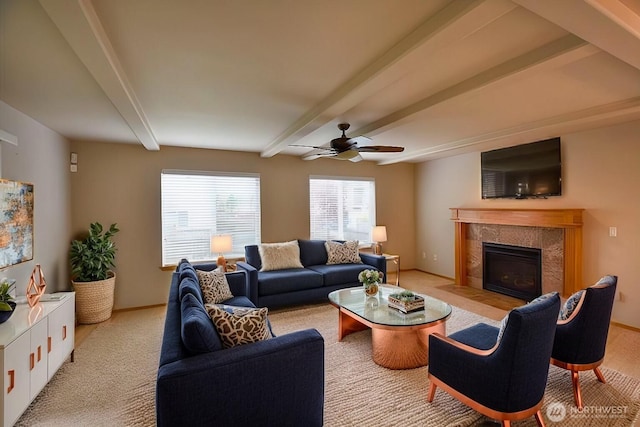 carpeted living room featuring ceiling fan, beam ceiling, and a tile fireplace