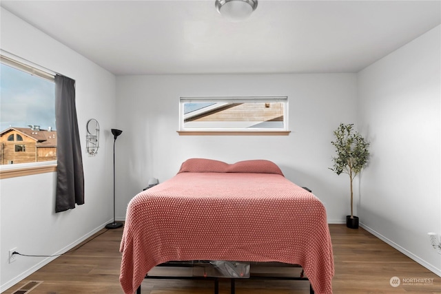 bedroom with wood-type flooring and multiple windows