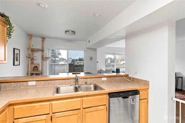 kitchen with kitchen peninsula, light brown cabinetry, dishwasher, wood-type flooring, and sink