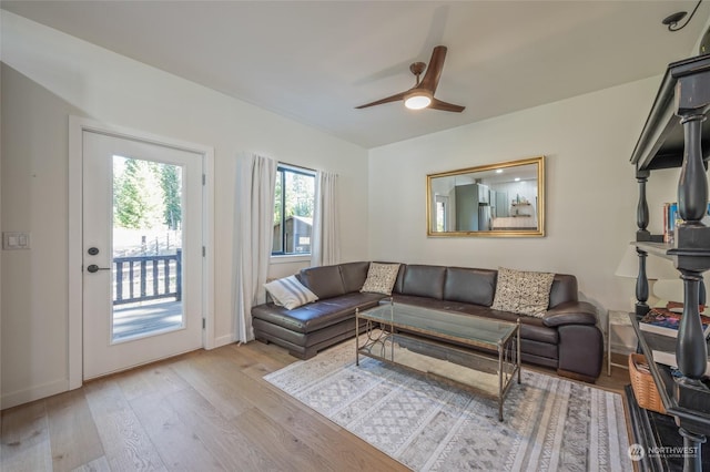 living room with light hardwood / wood-style flooring and ceiling fan