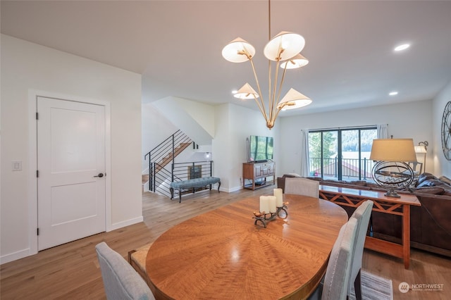 dining area with light wood-type flooring and a chandelier