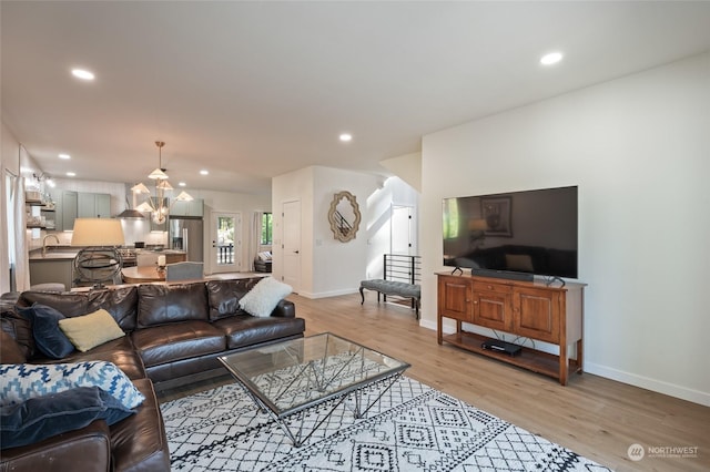 living room with light hardwood / wood-style floors and sink