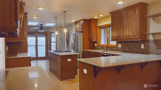 kitchen with a kitchen bar, kitchen peninsula, a skylight, and a kitchen island