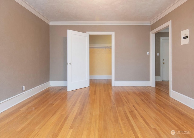 unfurnished bedroom featuring a closet, ornamental molding, a textured ceiling, and light hardwood / wood-style flooring